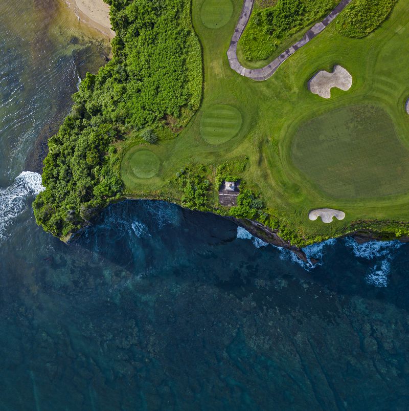 Aerial view of golf course with  green at coast