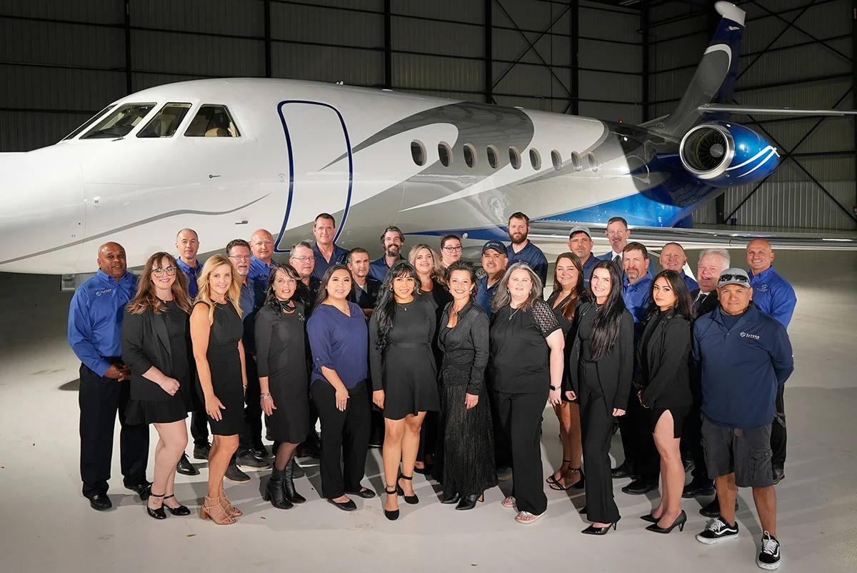 Saturn Aviation team standing in front of private jet in the hangar