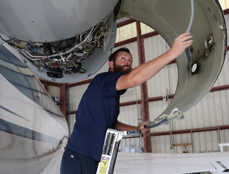 Aircraft maintenance worker looking at engine