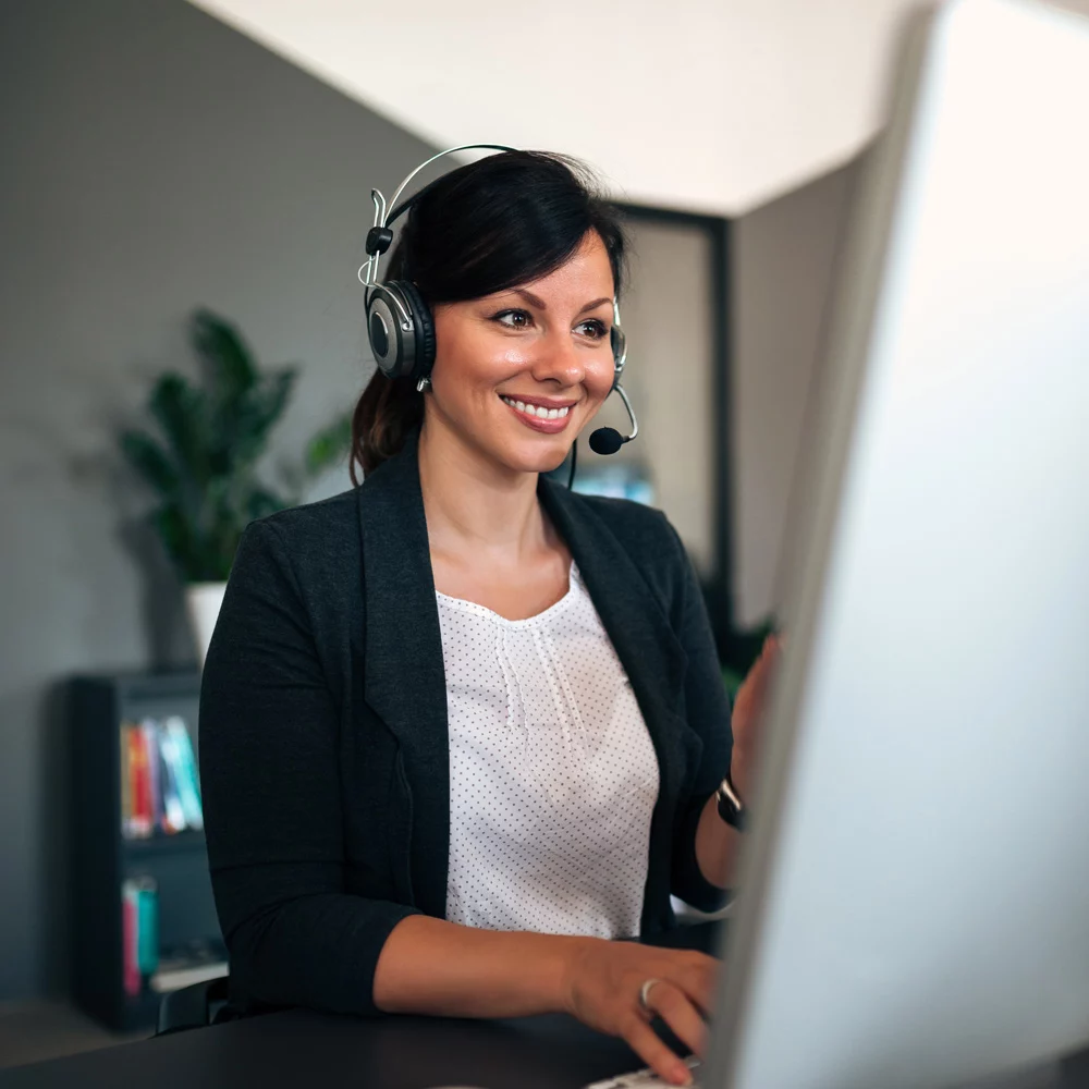 Woman at computer with headset on